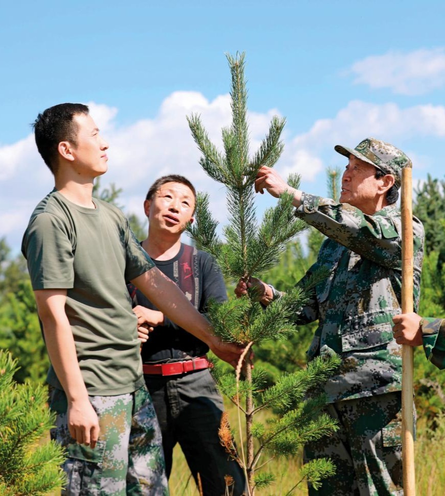 2025-08-03，张连印带着贫困户魏随舍和教育基地工作人员种树。（丁美宁 摄）